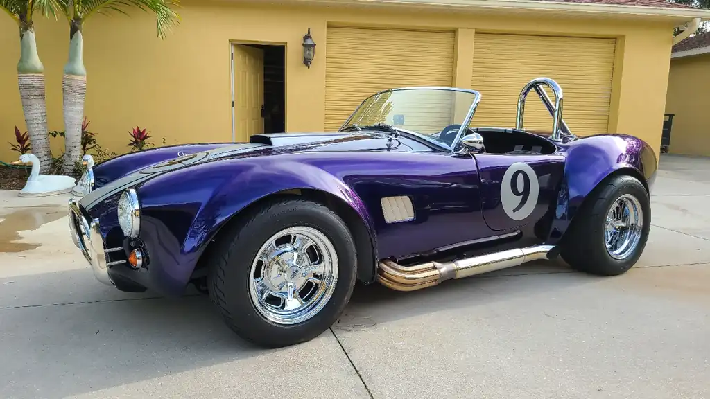 Purple Shelby Cobra replica with a white number 9 roundel, detailed on a Bradenton driveway