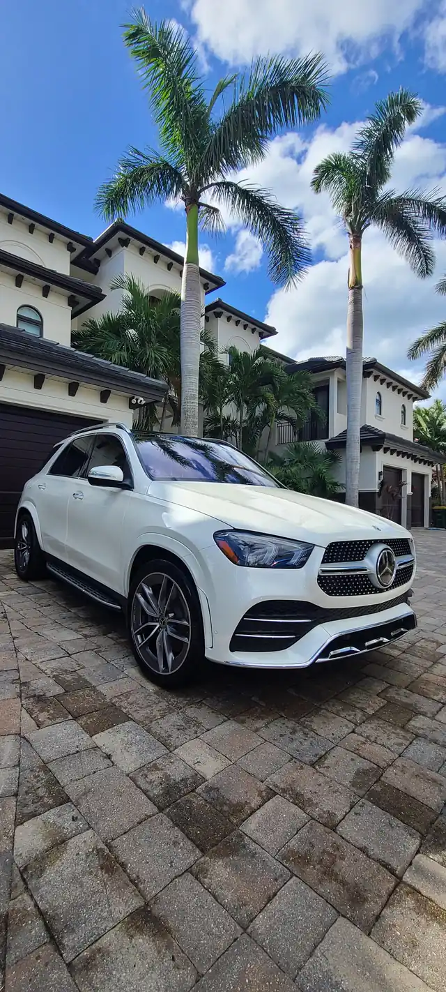 White Mercedes GLE parked under palm trees