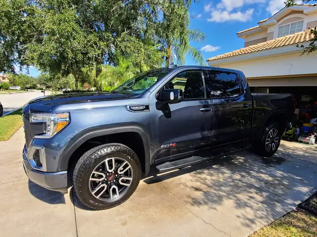Slate GMC Sierra AT4 pickup after a detail, parked on a sunny driveway