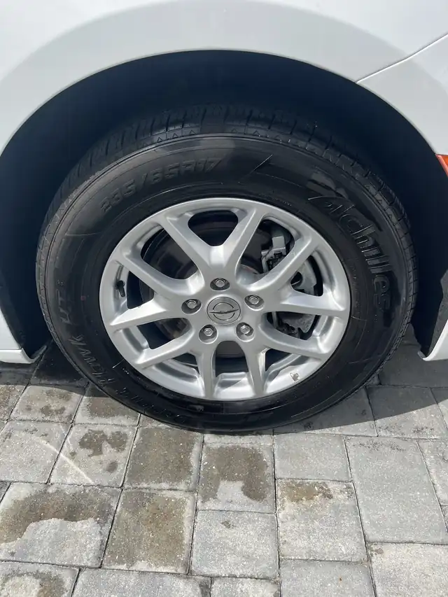Alloy wheel and dressed tyre on a white car after a wheel, wheel well and tire detail