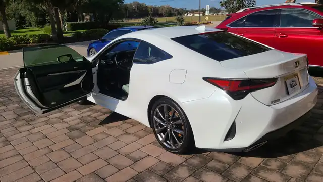 White Lexus RC coupe on pavers with the driver's door open after a detail