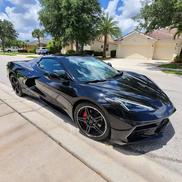 Black C8 Corvette on a driveway, sealed paint and red calipers