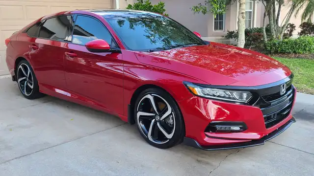 Red Honda Accord after an exterior detail, paint reflecting the house